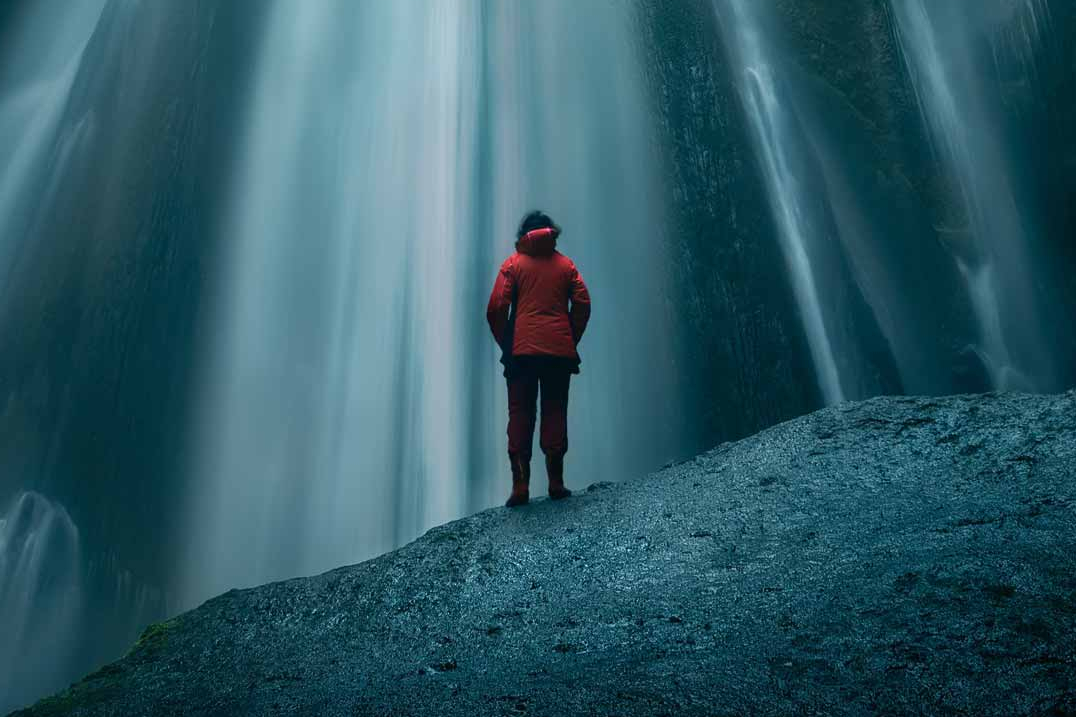 Person steht vor einem Wasserfall