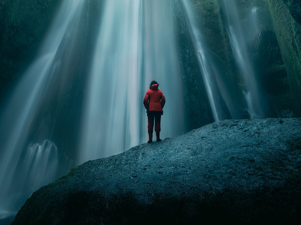 fintego green+ Person steht vor einem Wasserfall